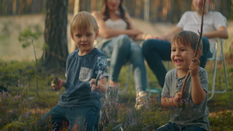 Children-sit-by-the-fire-and-look-at-the-fire-playing-with-sticks